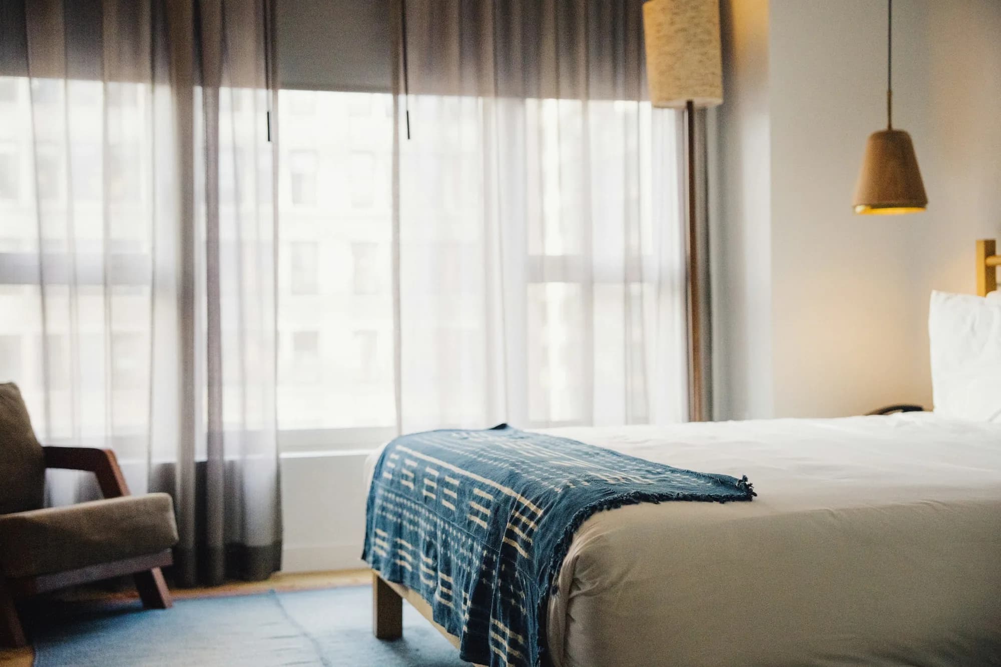 A bright, tidy hotel room with a made bed